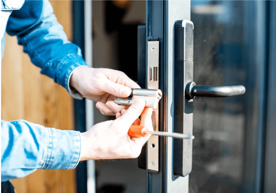 Technician fitting a lock cylinder into an aluminium door